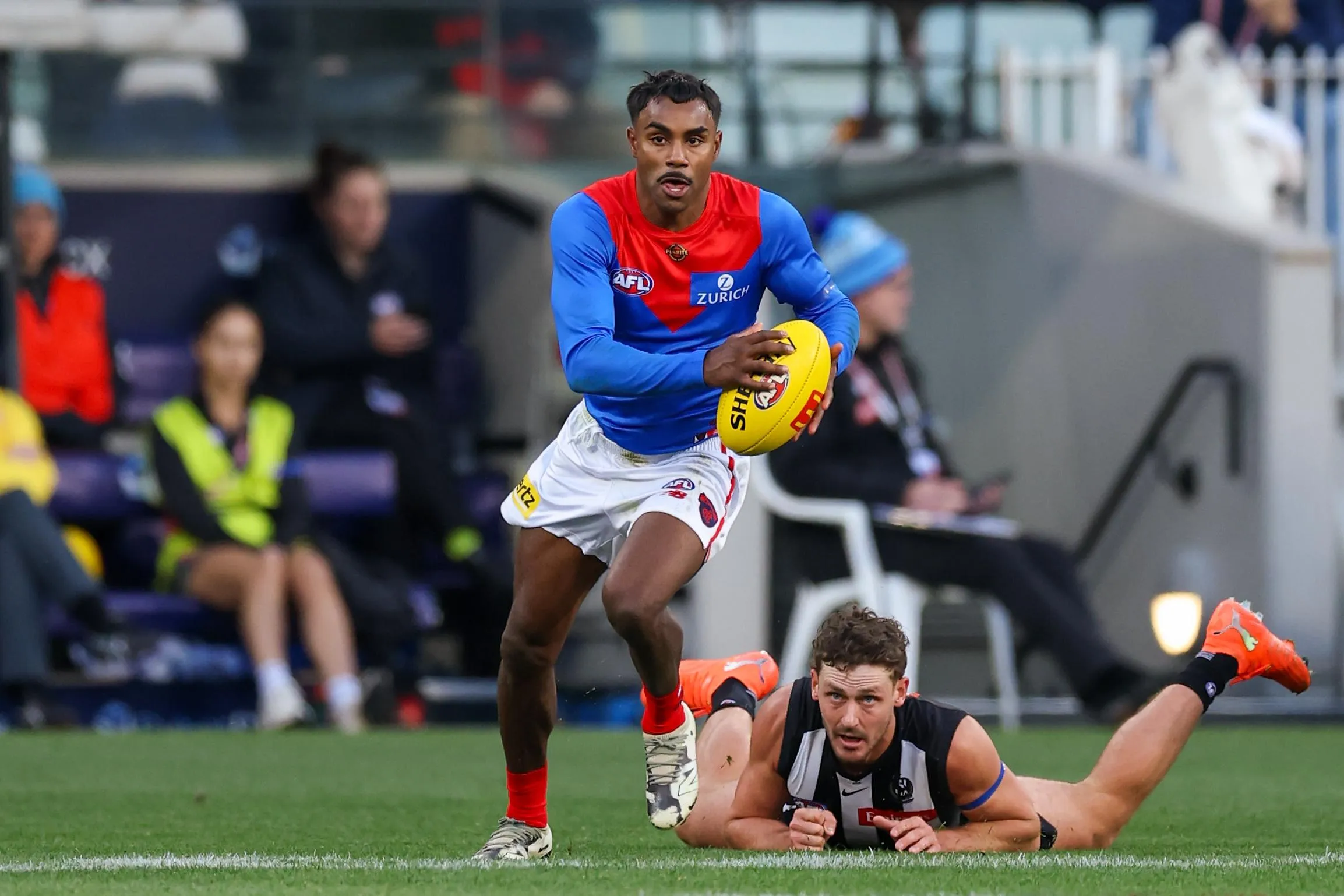 Pickett runs away from a Magpies player who is on the ground