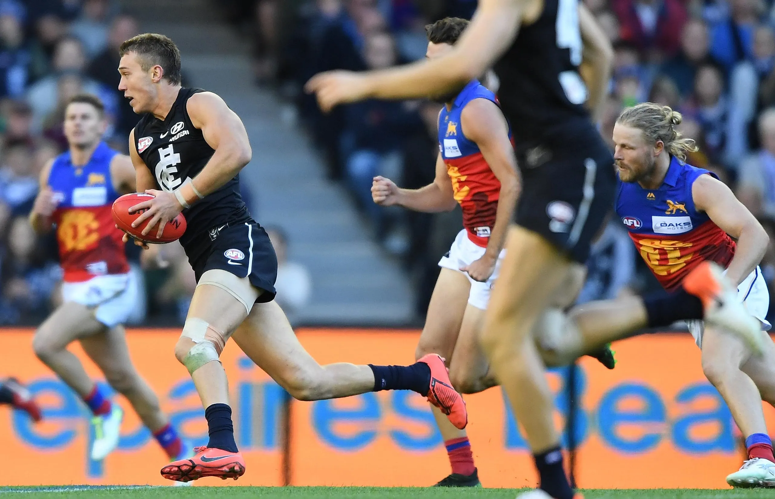 Patrick Cripps is chased by Brisbane players during a 2019 AFL game