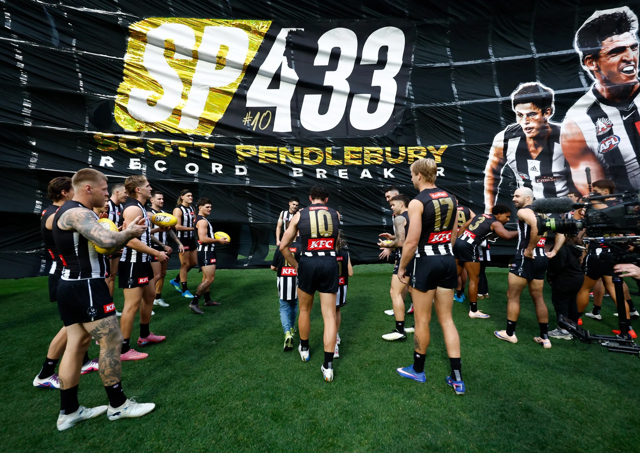 Scott Pendlebury runs through the Collingwood Magpies banner while breaking the VFL/AFL games record in his 433rd match