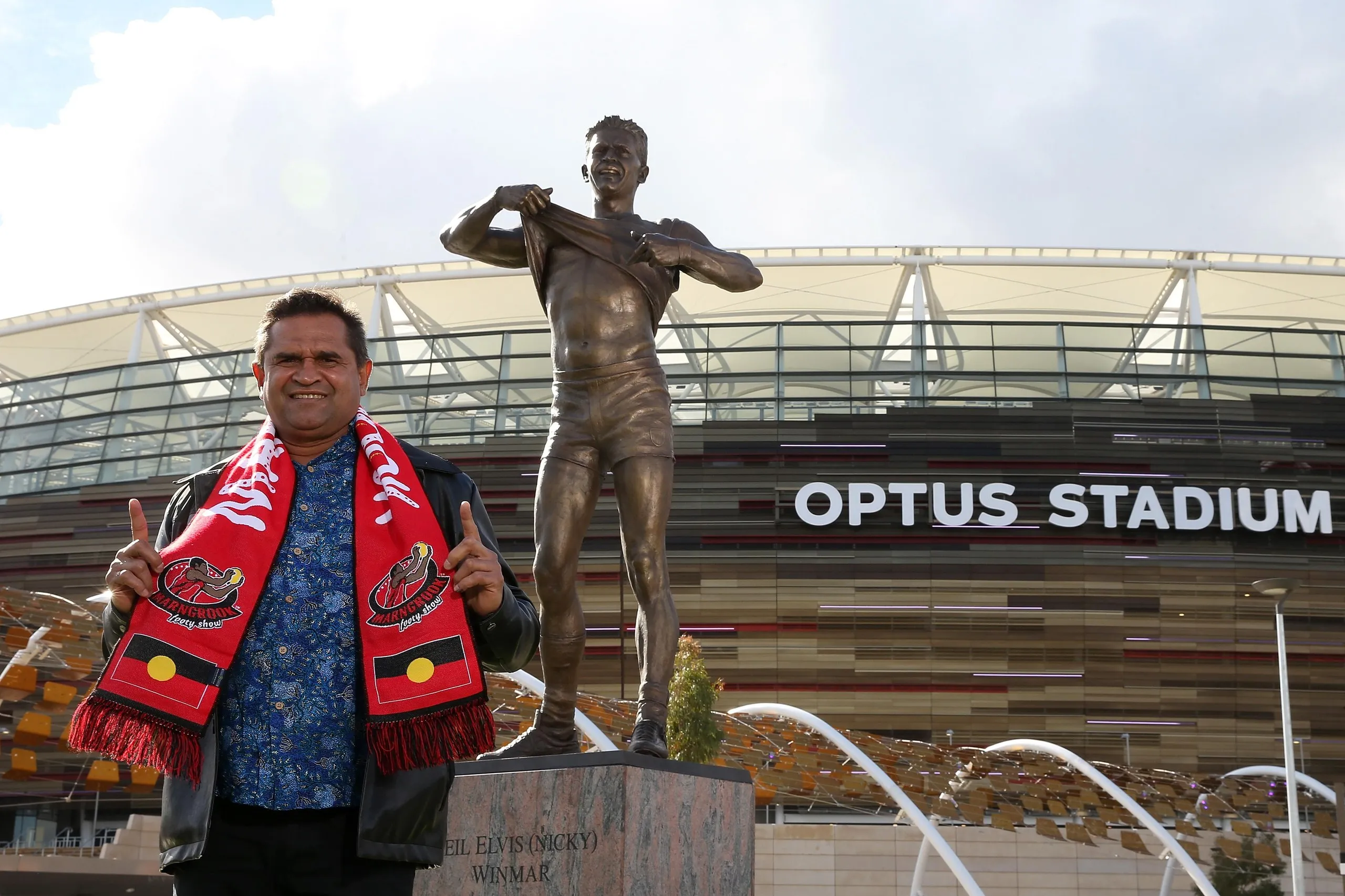 Nicky Winmar poses with his statue after it was unveiled at Optus Stadium on 6 July 2019.