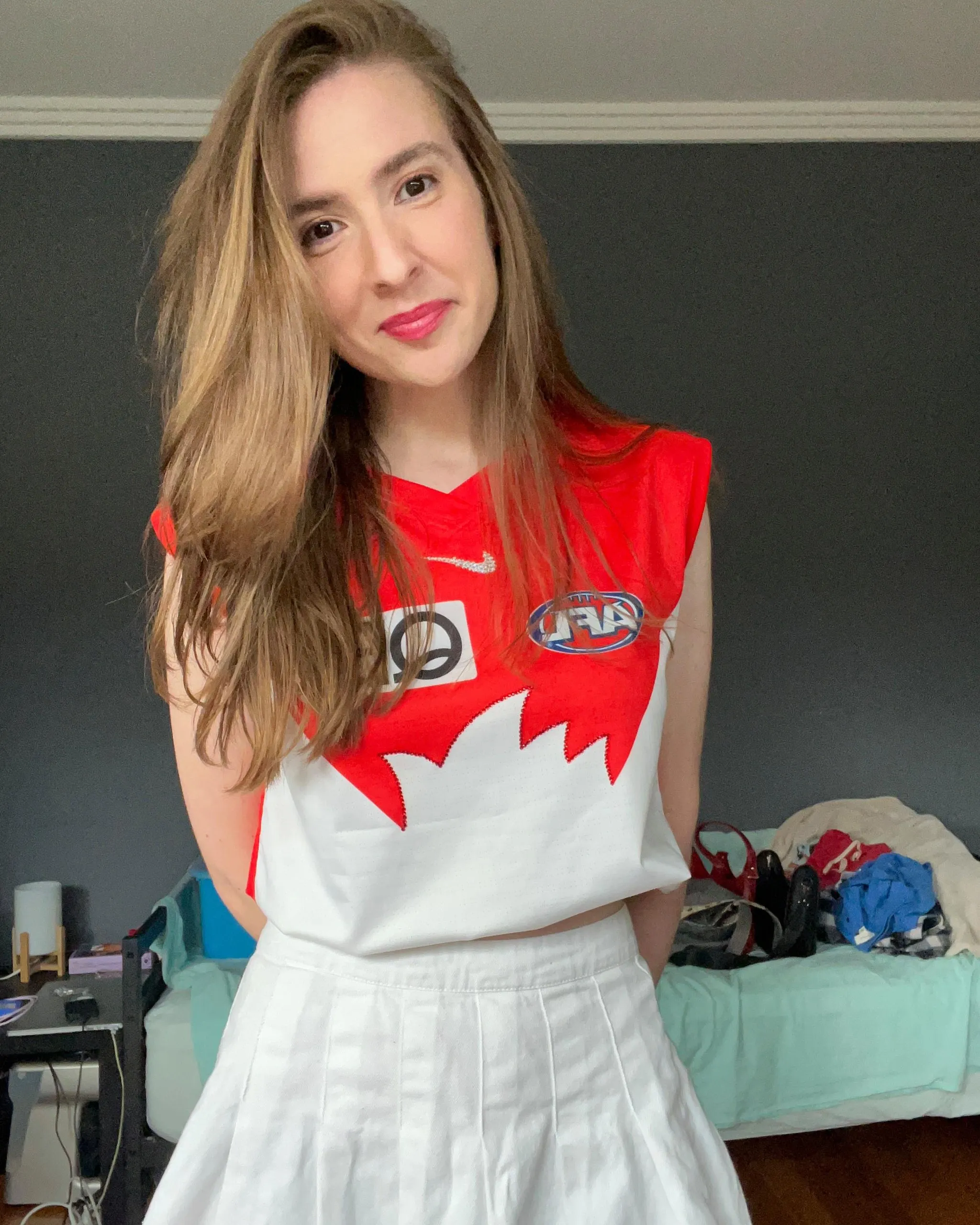 A woman wearing a Swans jersey and white skirt 