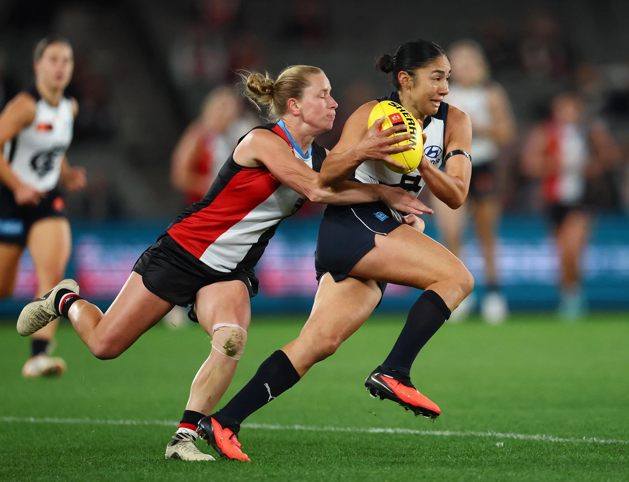 A running Darcy Vescio is tackled by Jaimee Lambert of the Saints