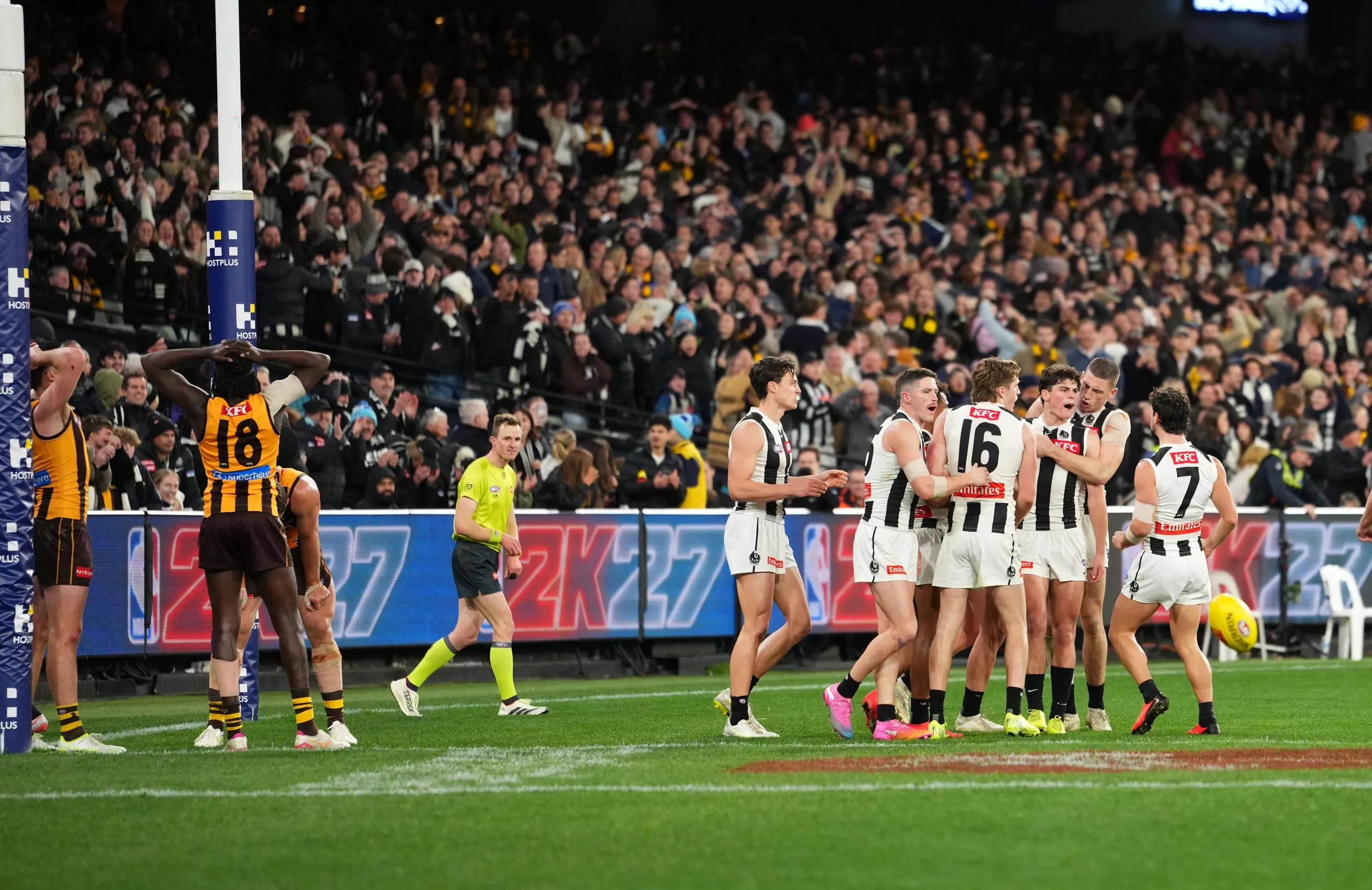 Collingwood players react after Hawthorn’s Dylan Moore missed a shot at goal after the siren.