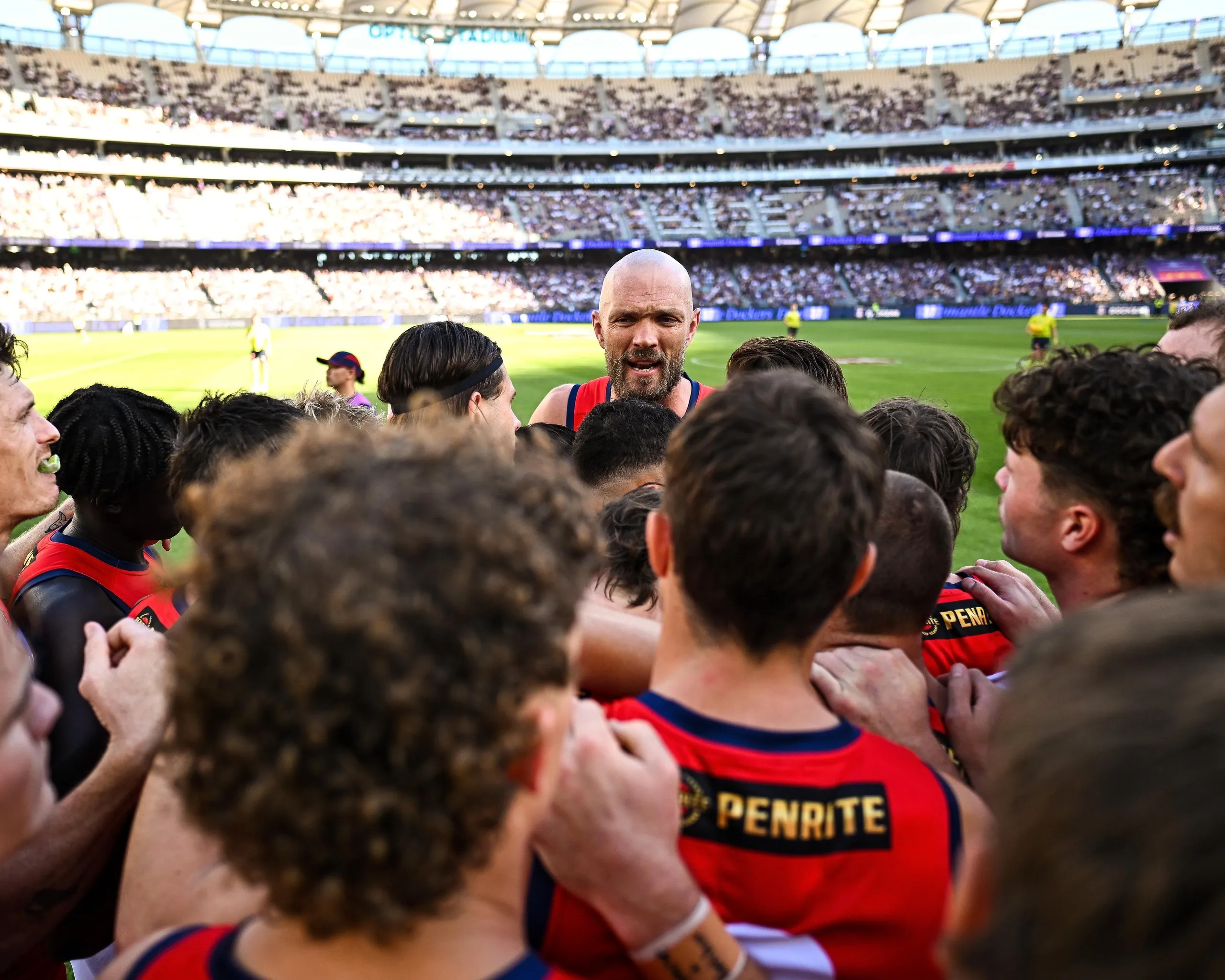Max Gawn speaks to Demons teammates in a huddle 