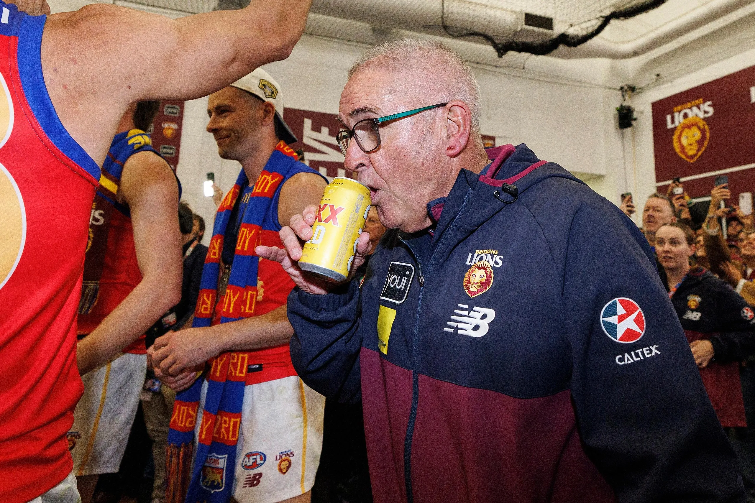 Chris Fagan celebrates with a beer after the AFL grand final.