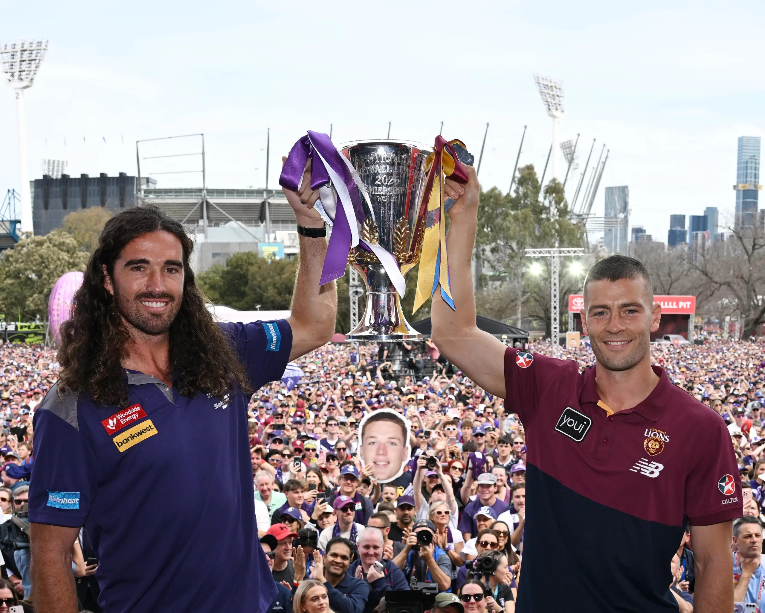 Fremantle captain Alex Pearce and Brisbane co-captain Josh Dunkley hold the AFL premiership cup