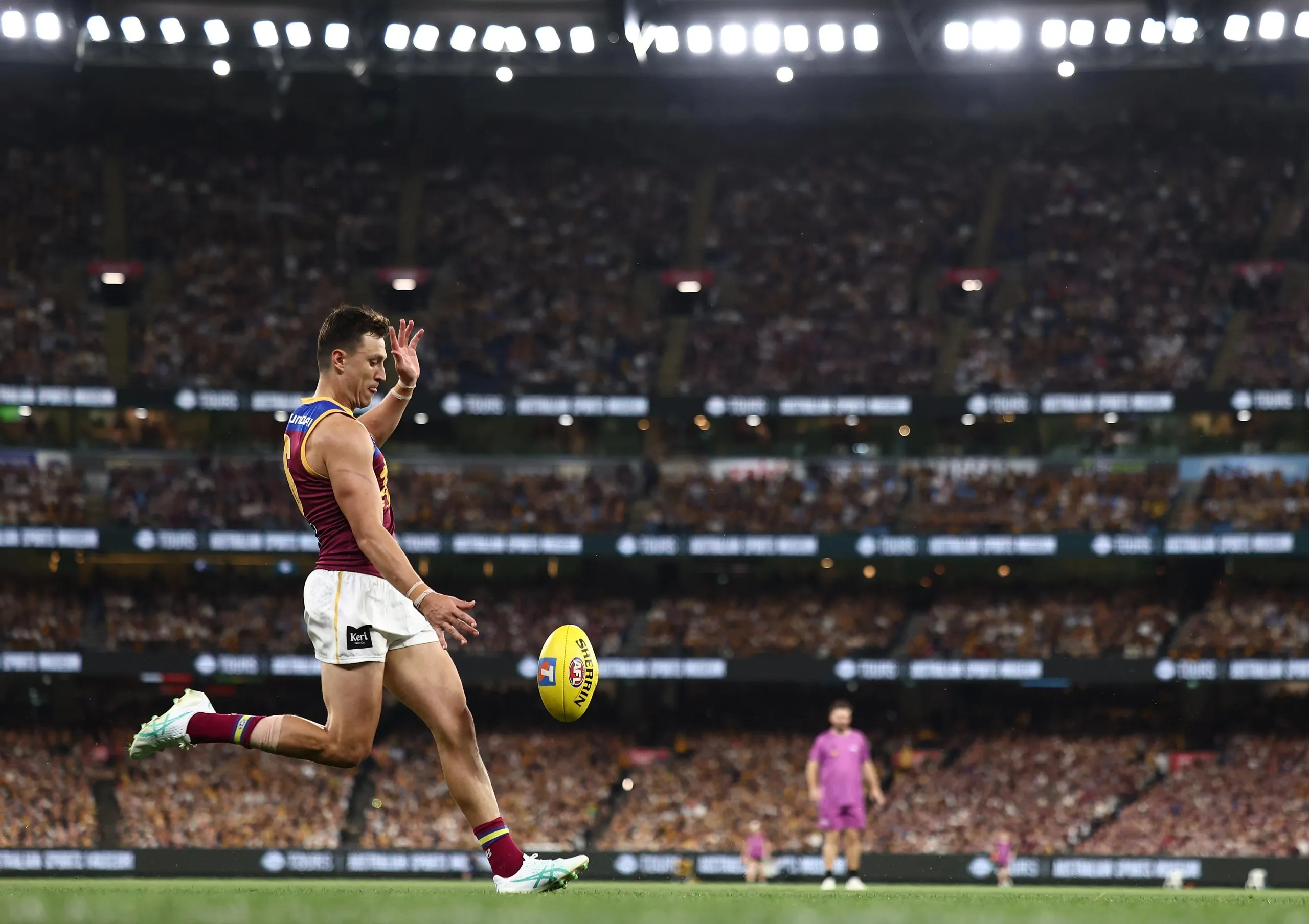 Hugh McCluggage kicks for goal with a view of the MCG stands behind him