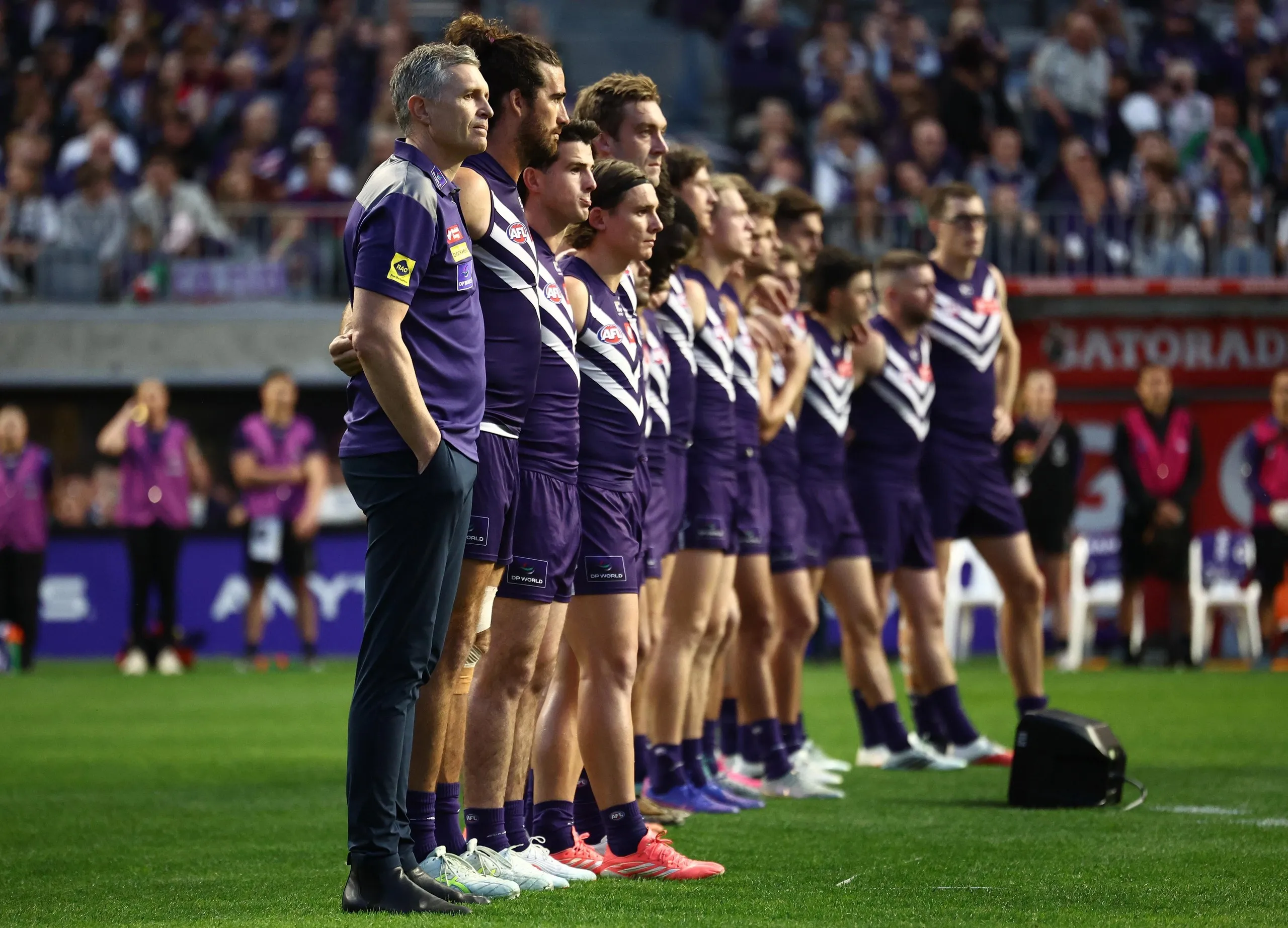 Justin Longmuir stands with Fremantle players as they prepare to face Geelong in an AFL semi-final at Optus Stadium