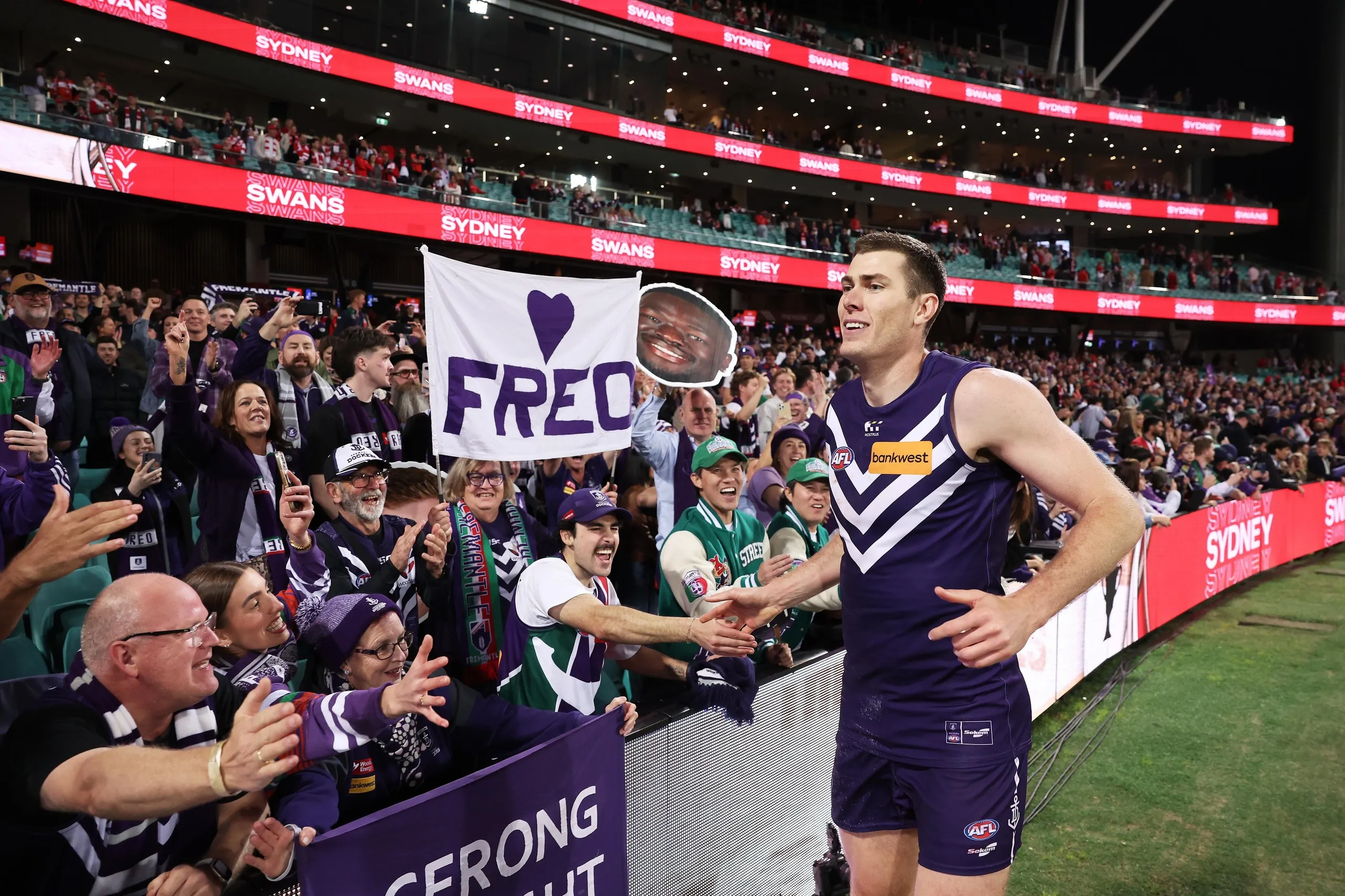 Mason Cox high fives fans in the crowd after the match