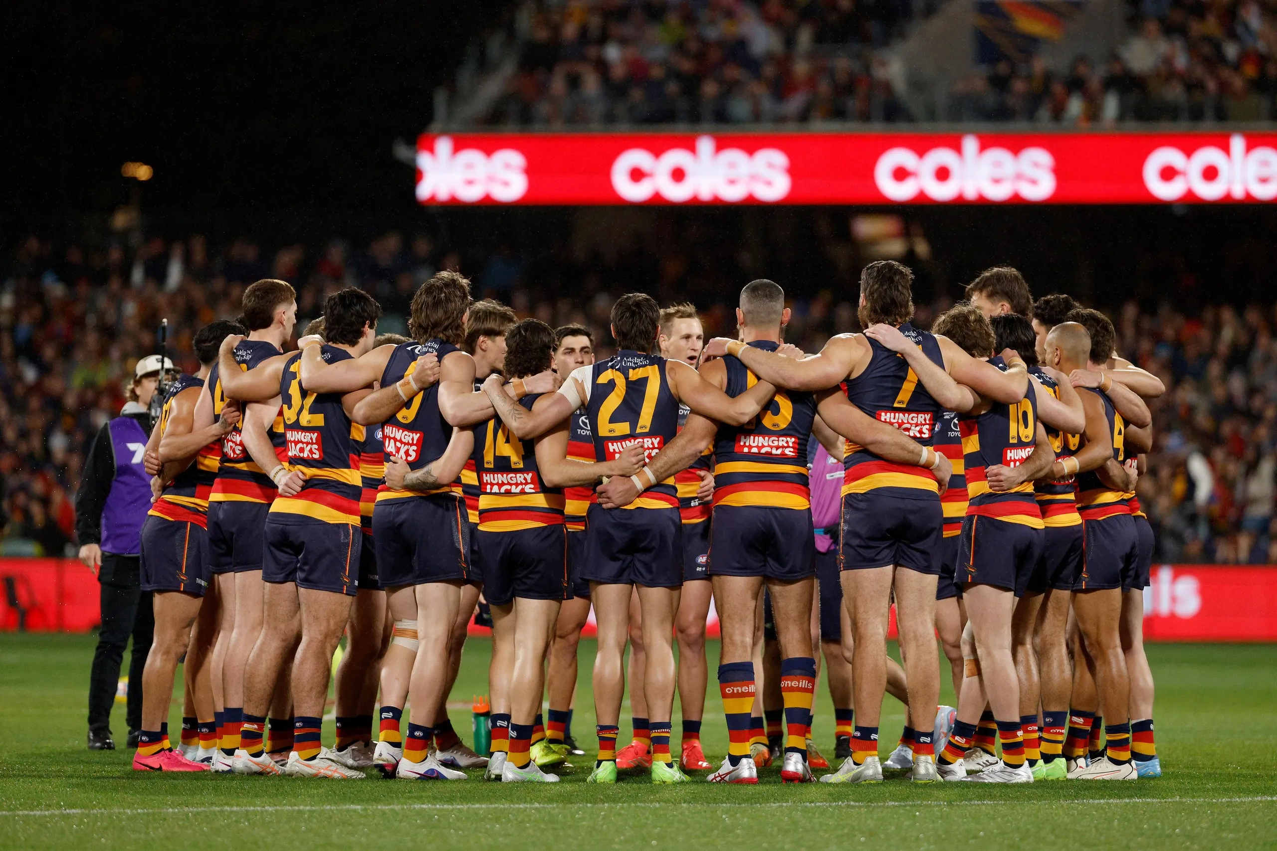 Jordan Dawson of the Crows talks in a team huddle.